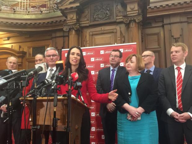Jacinda Ardern speaks to the press alongside members of her party after Andrew Little stepped down in Wellington, New Zealand